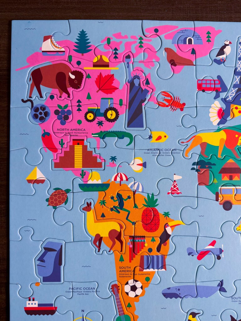Close-up of North and South America on the completed world map geography puzzle.