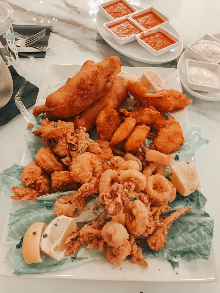 Fried seafood platter with shrimp, fish, calamari, fries, and dipping sauces at Sugar Factory Biloxi.