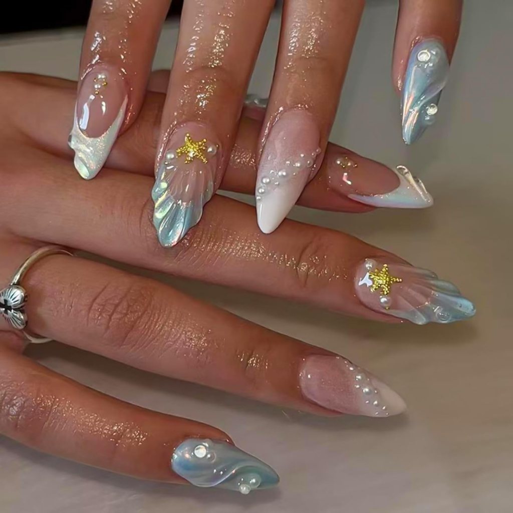 Glossy beach-inspired French tip ocean nails with pearl accents and soft blue seashell manicure design