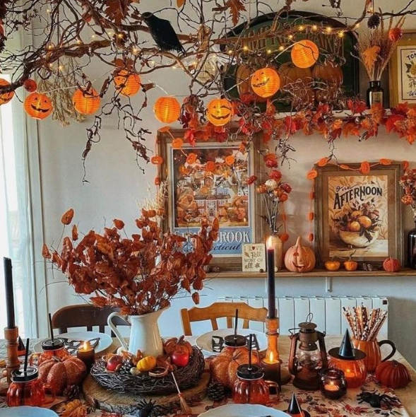 A cozy fall tablescape featuring autumn leaves, pumpkin decorations, and warm candles, creating an inviting atmosphere with vintage elements.