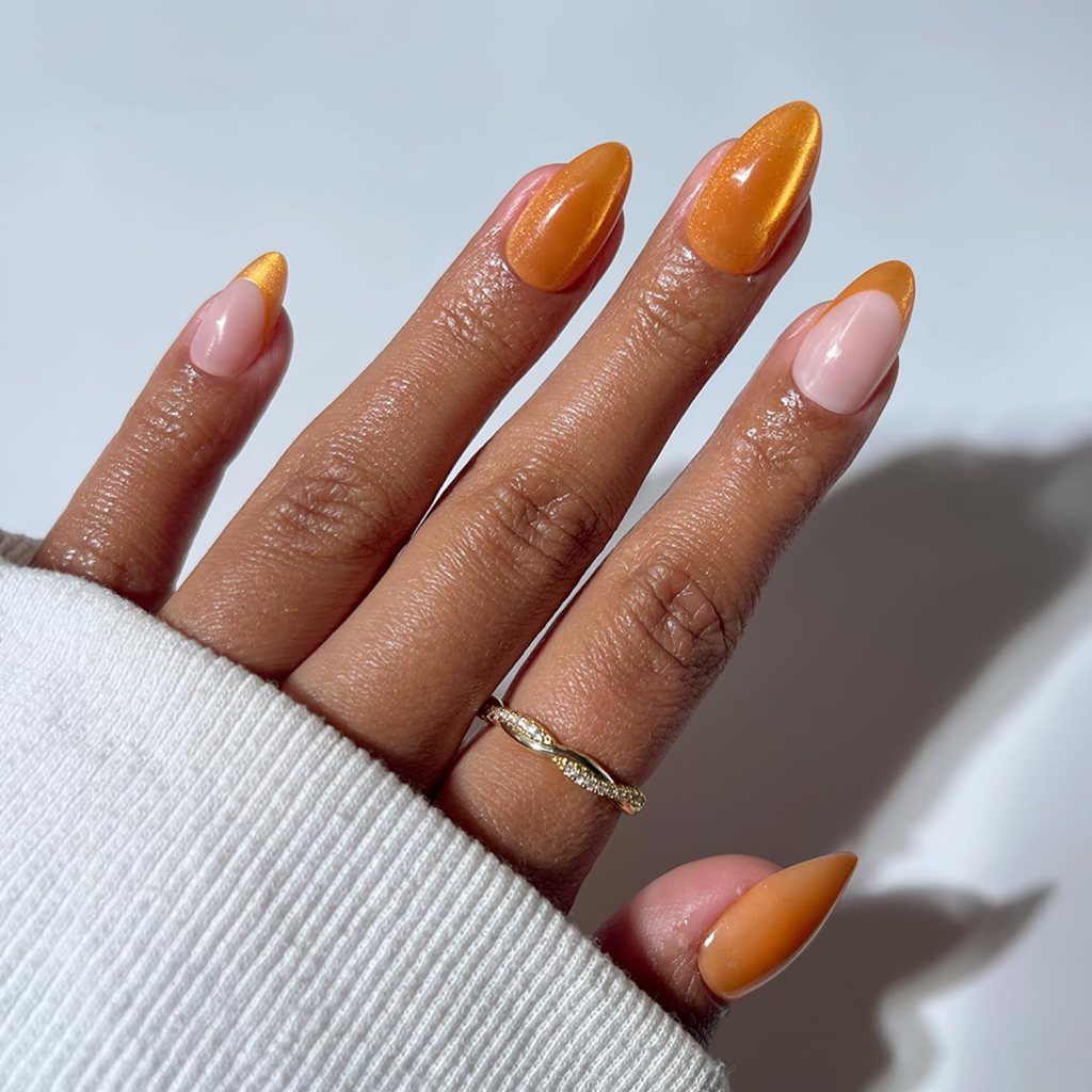 Almond-shaped nude nails with metallic orange French tips and glossy finish
