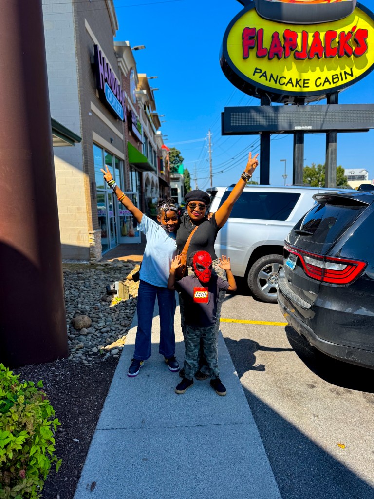 Family posing together outside Flapjack's Pancake Cabin during a Pigeon Forge family vacation.