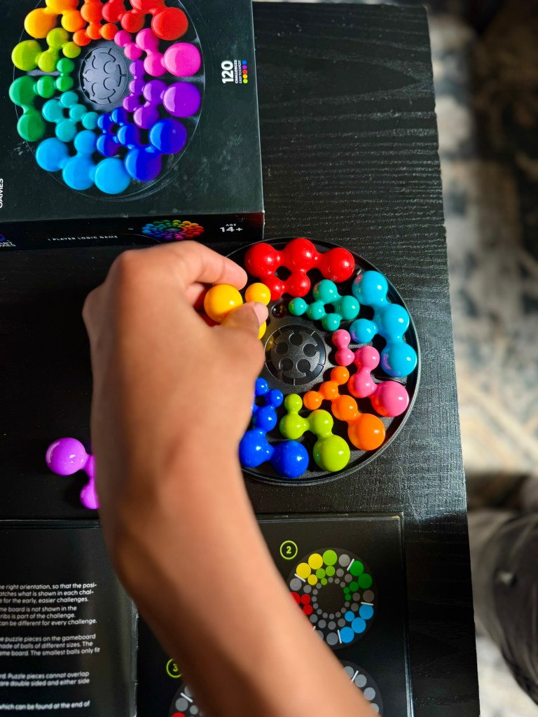 Child working through an IQ Circle starter challenge using the colorful pieces