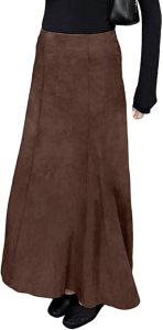 A person wearing a black long-sleeve top paired with a flowing brown suede maxi skirt, holding a handbag.