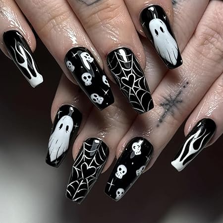 Black nails with white ghost, skull, and spiderweb designs, creating a spooky Halloween nail art look.