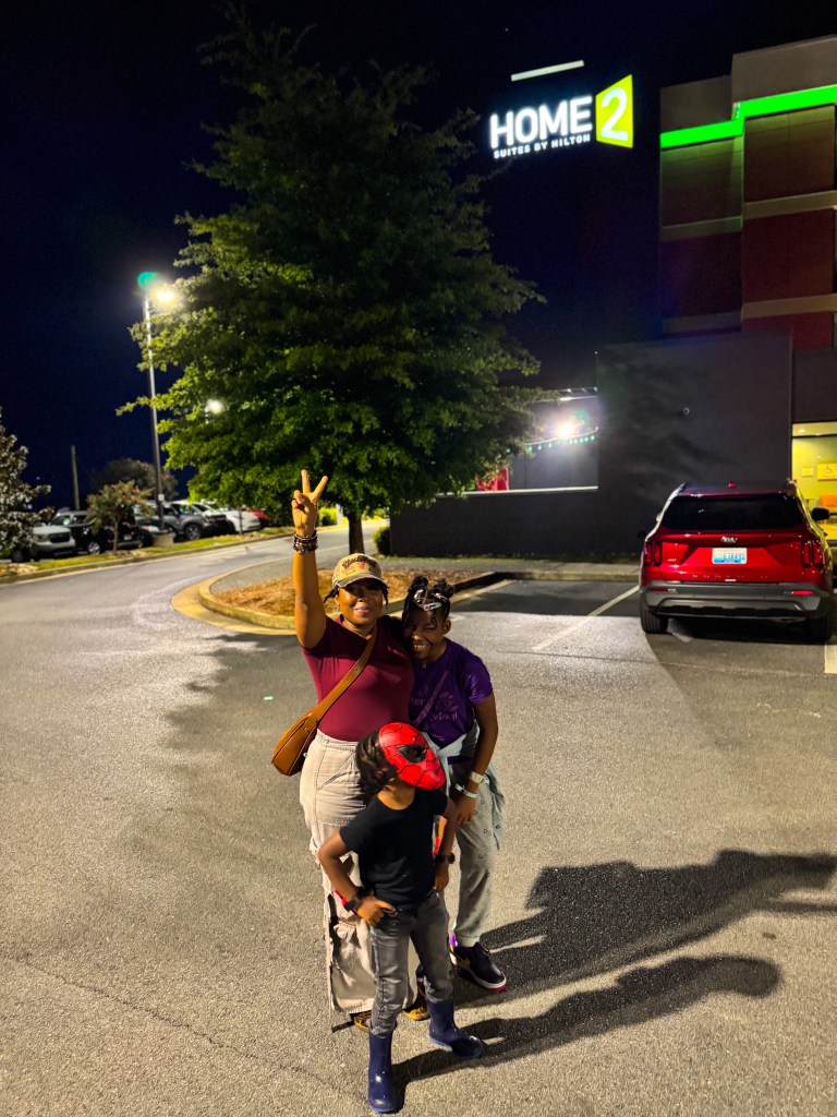 Family posing together outside Home2 Suites Pigeon Forge on a family vacation.