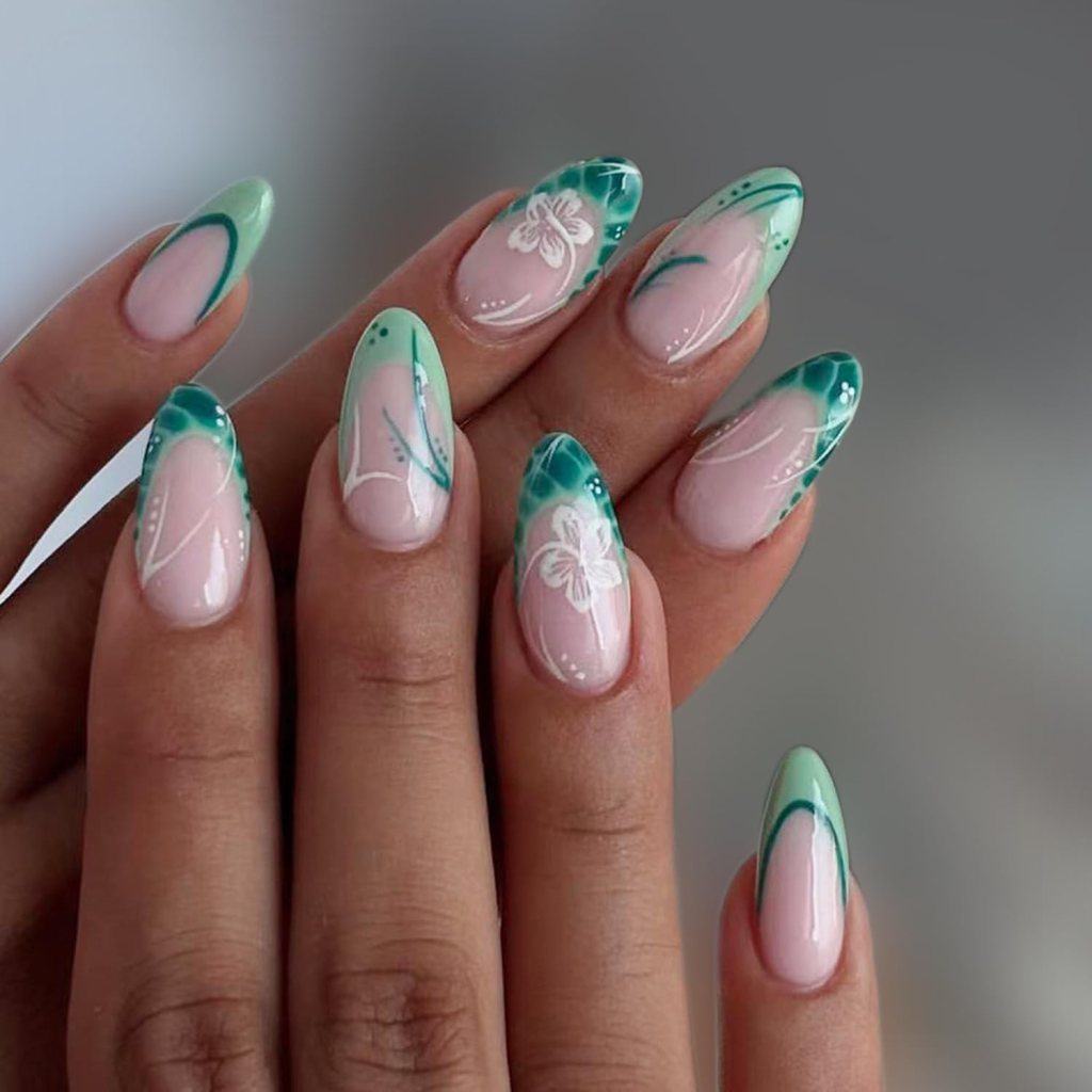 A close-up of elegantly manicured nails featuring a mix of green and pastel pink shades, decorated with floral designs and intricate patterns.