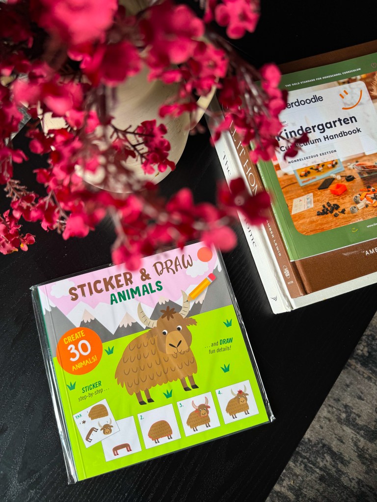 Sticker and Draw Animals activity book beside the Timberdoodle Kindergarten Curriculum Handbook.