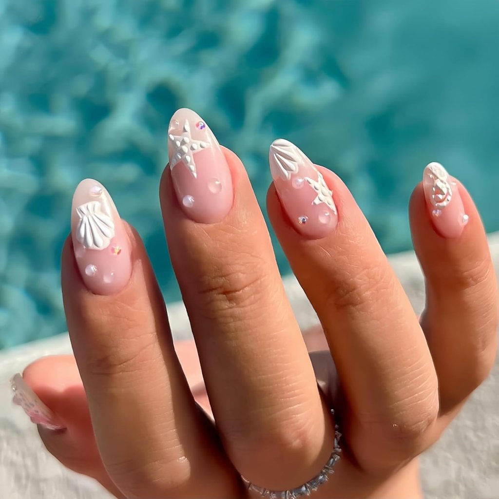Dreamy mermaid ocean nails with pearl embellishments, shell textures, and glossy blue chrome nail details