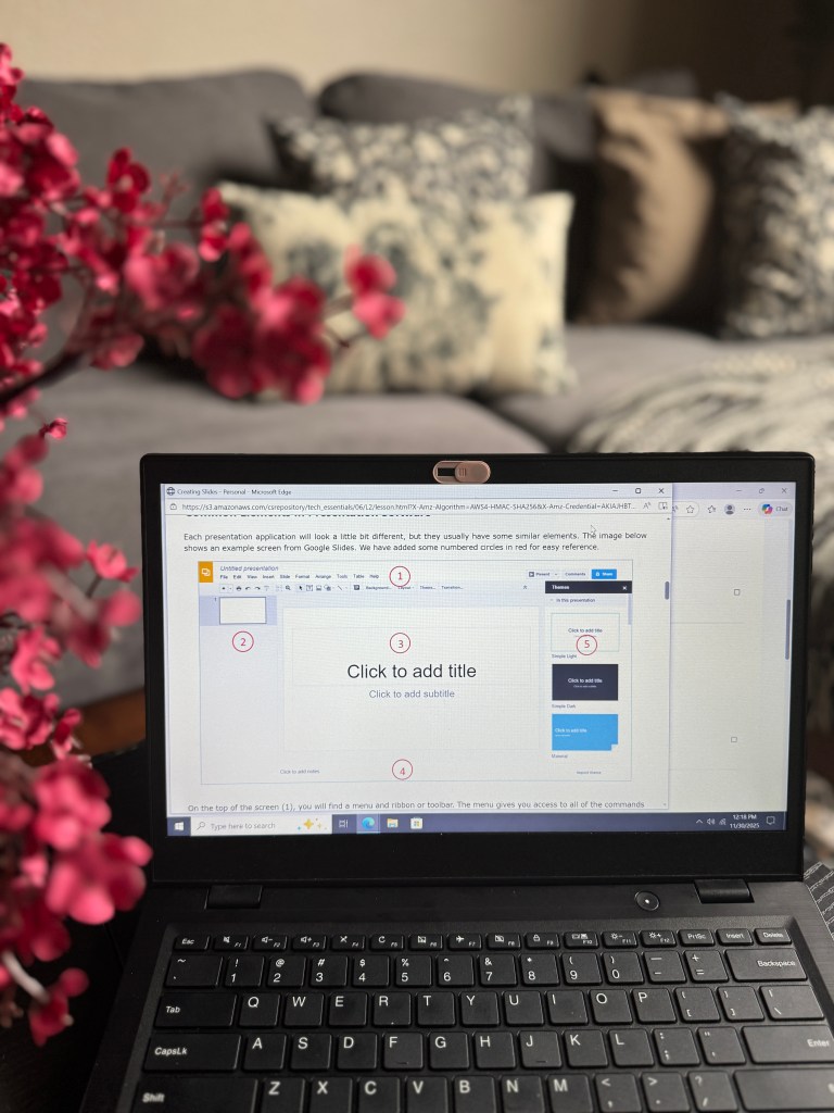 A laptop displaying a presentation software interface with instructional elements highlighted, alongside a floral arrangement and a cozy living room background.