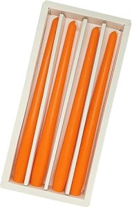 A set of orange taper candles neatly arranged in a white holder, perfect for adding a pop of color to a fall tablescape.