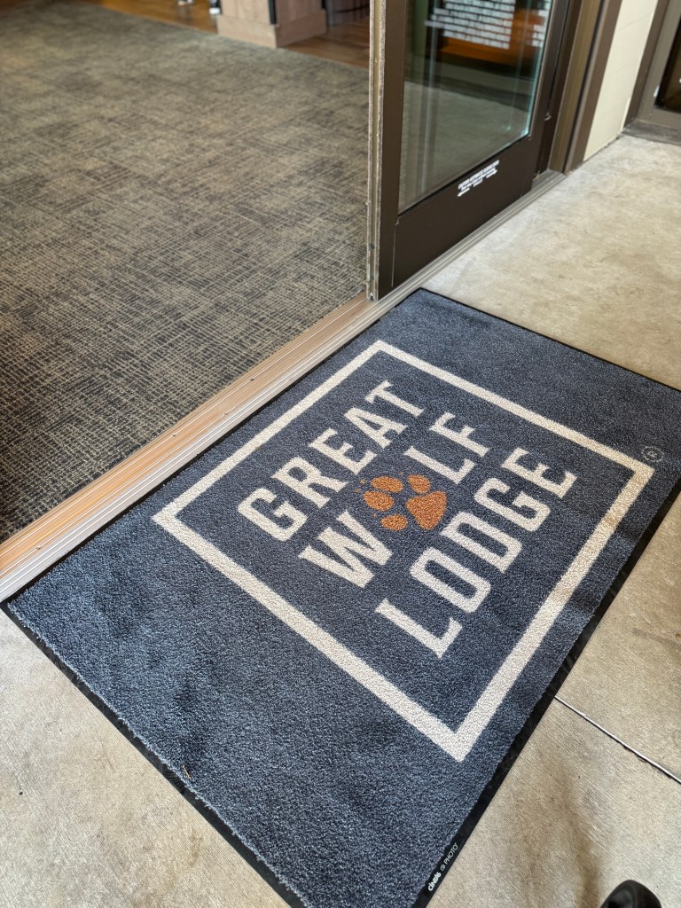 Entrance mat of Great Wolf Lodge featuring the lodge's logo and a paw print design.