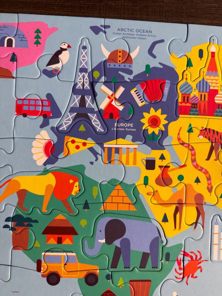 Close-up of Africa, Europe and Asia on a colorful world geography puzzle for kids.