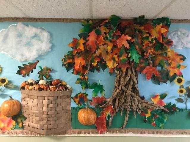 Fall harvest bulletin board featuring a textured autumn tree, colorful leaves, pumpkins, sunflowers and a woven-style harvest basket.