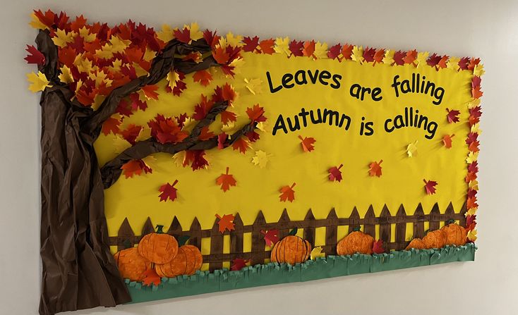 Leaves Are Falling, Autumn Is Calling bulletin board with a large autumn tree, pumpkin patch, fence and colorful fall leaves.