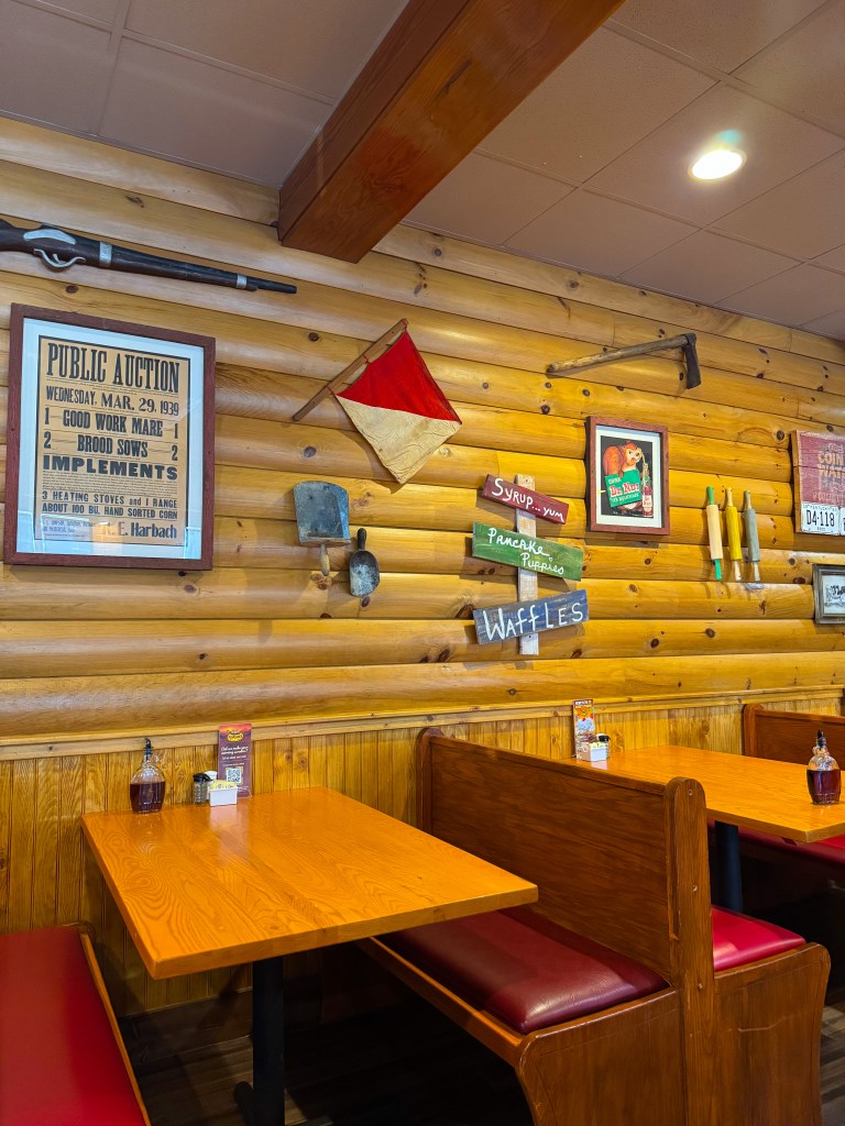 Vintage dairy farm signs and rustic wooden walls inside Flapjack's Pancake Cabin in Pigeon Forge, Tennessee.