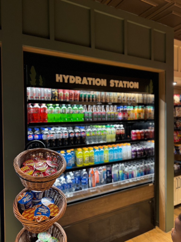 A hydration station offering a variety of beverages including sodas, sports drinks, and water, with snacks displayed in woven baskets nearby.