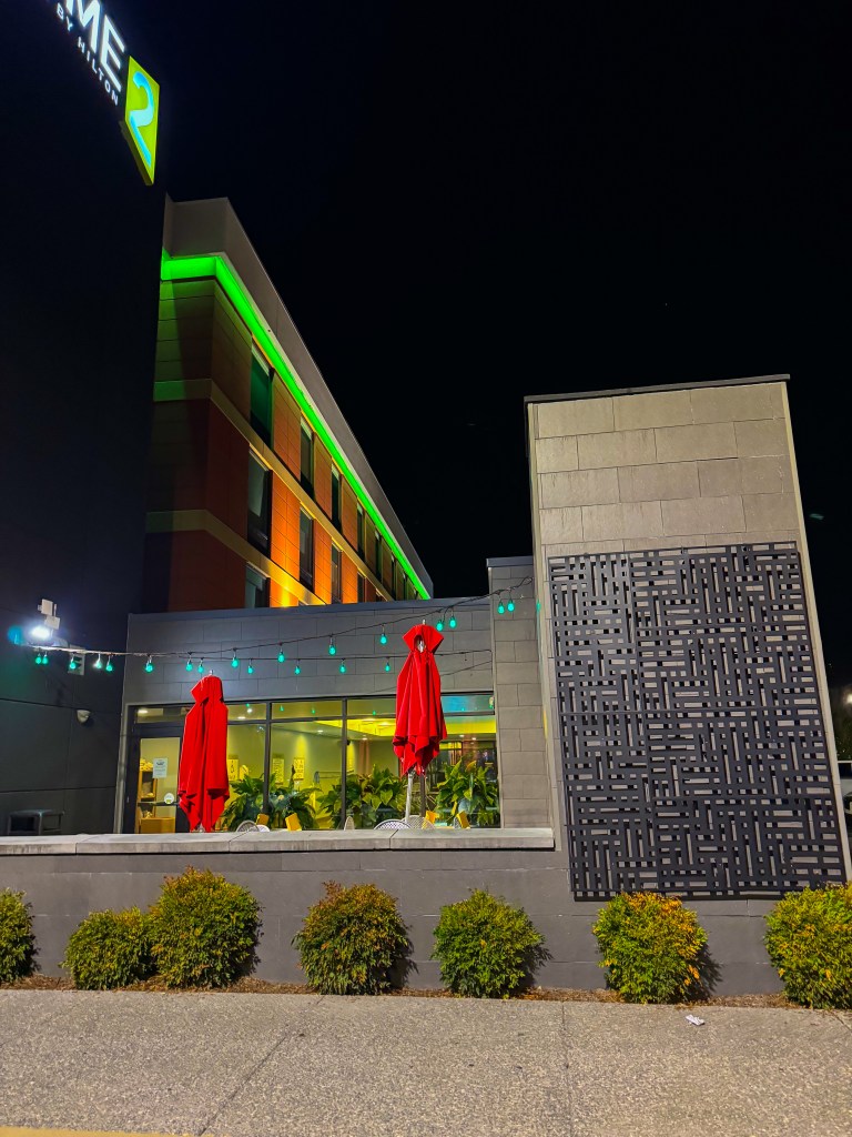 Exterior of Home2 Suites Pigeon Forge illuminated at night beside the outdoor patio.