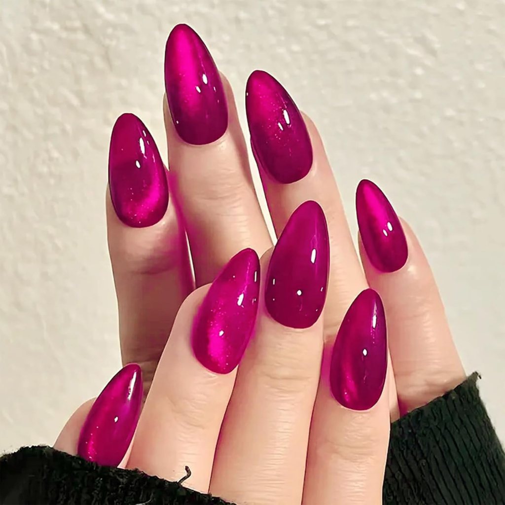 Stylish hands with long, almond-shaped nails painted in glossy magenta polish.