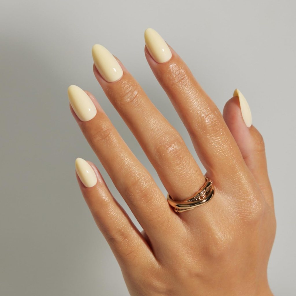 Glossy butter yellow coffin nails with soft pastel yellow polish and sleek modern manicure aesthetic