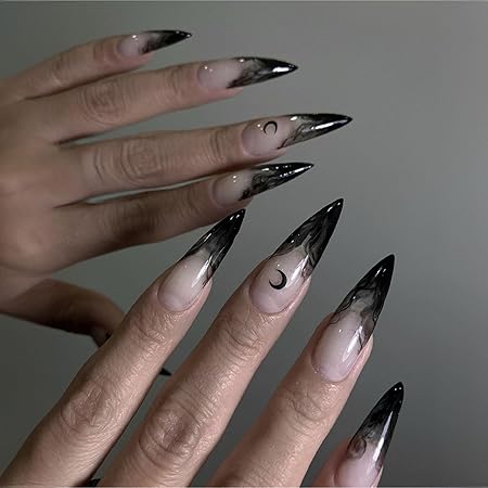 Close-up of elegant stiletto nails featuring a black ombre design, transitioning from nude to dark tips, with crescent moon accents.