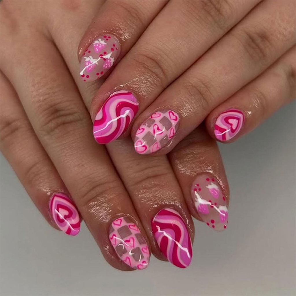 Close-up of manicured nails featuring various pink designs including hearts, stripes, and dots on a neutral background.