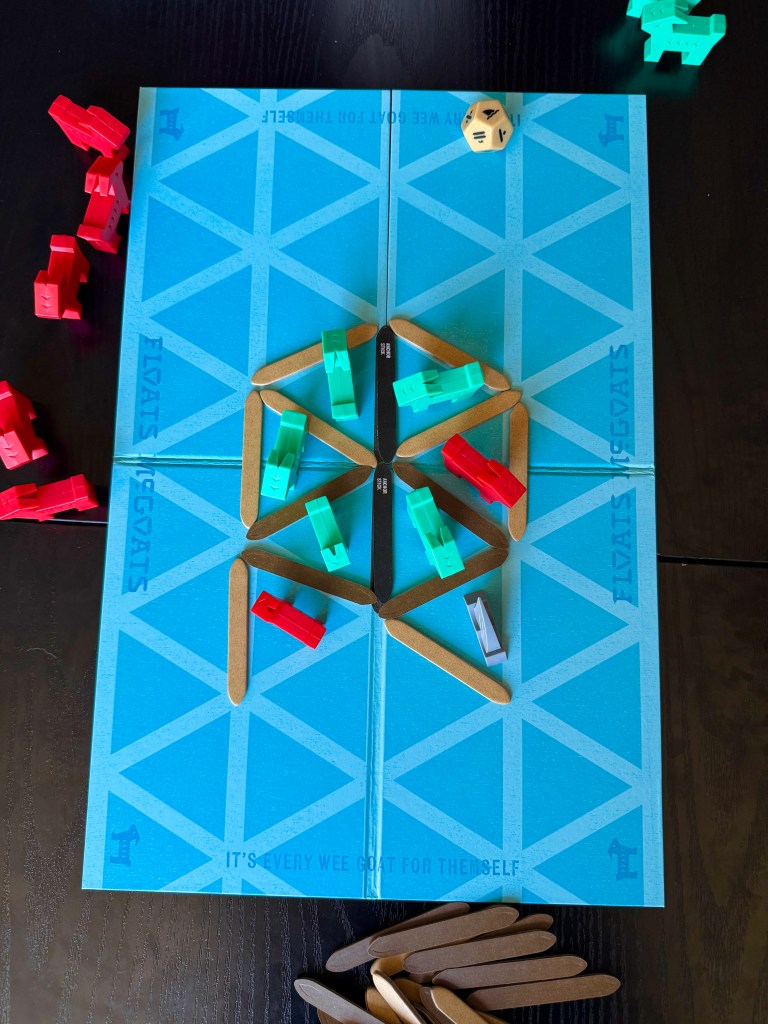 A board game setup featuring a blue board with diamond patterns, multiple colored game pieces in red, green, and white, a pair of dice, and wooden sticks scattered nearby.