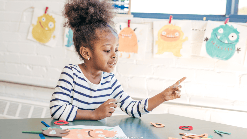 Young child creating a craft with paper pieces during an art learning activity for preschoolers.