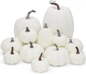 A collection of white pumpkins of various sizes, showcasing their smooth textures and contrasting dark stems, arranged artistically for a festive autumn display.