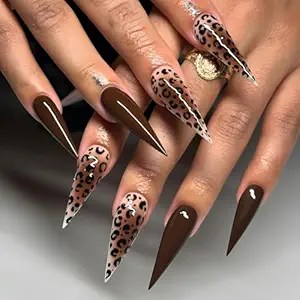 A close-up of stylish stiletto nails featuring a mix of rich chocolate brown and a soft nude base adorned with leopard print designs.