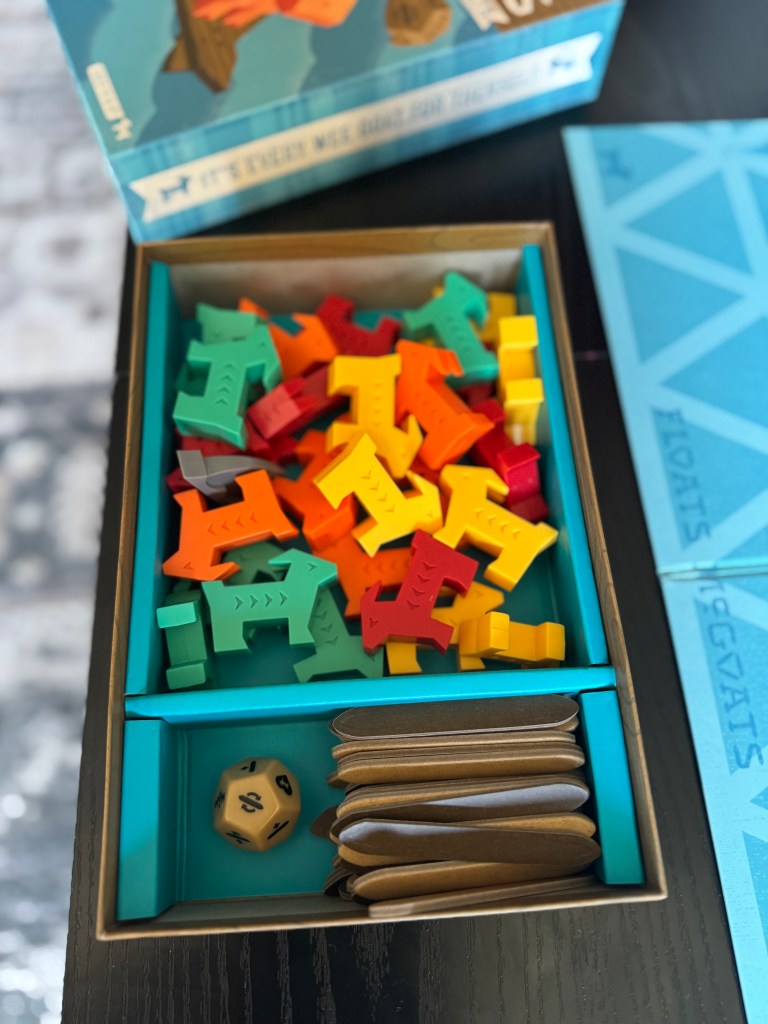 A box of a board game featuring colorful animal-shaped game pieces in red, green, orange, yellow, and blue, alongside a six-sided dice and card pieces.
