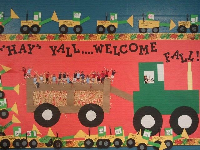 Welcome fall bulletin board featuring a large green tractor, hayride wagon and student-themed autumn decorations.