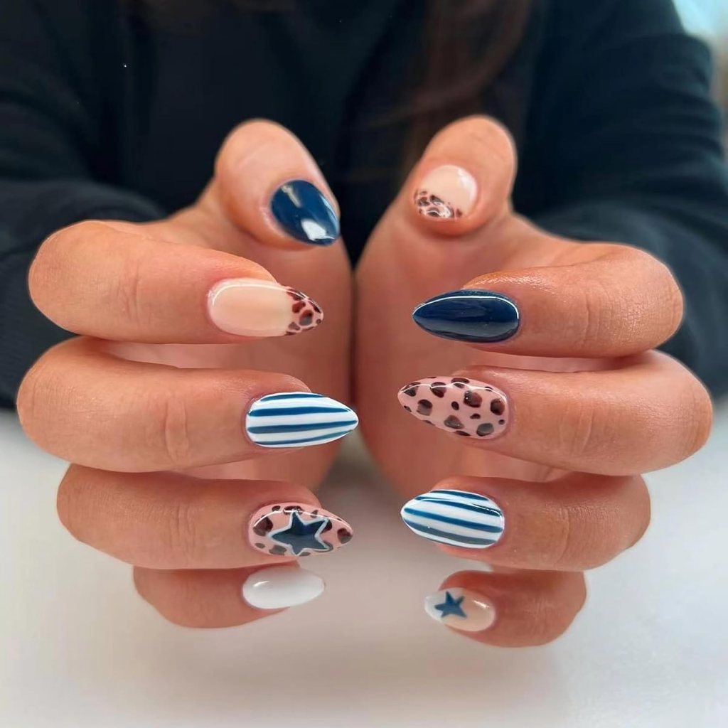 Navy blue leopard print almond nails with striped nail art, star accents, and glossy mix-match manicure.