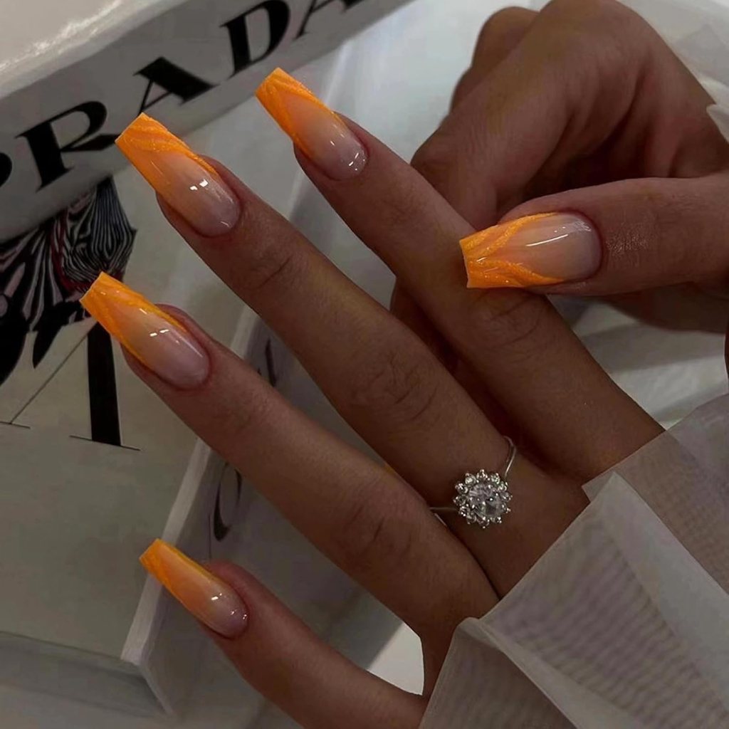 Square nails with nude base and bright orange French tip manicure