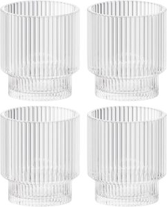 Four clear glass votive candle holders with ribbed texture, arranged in a set.