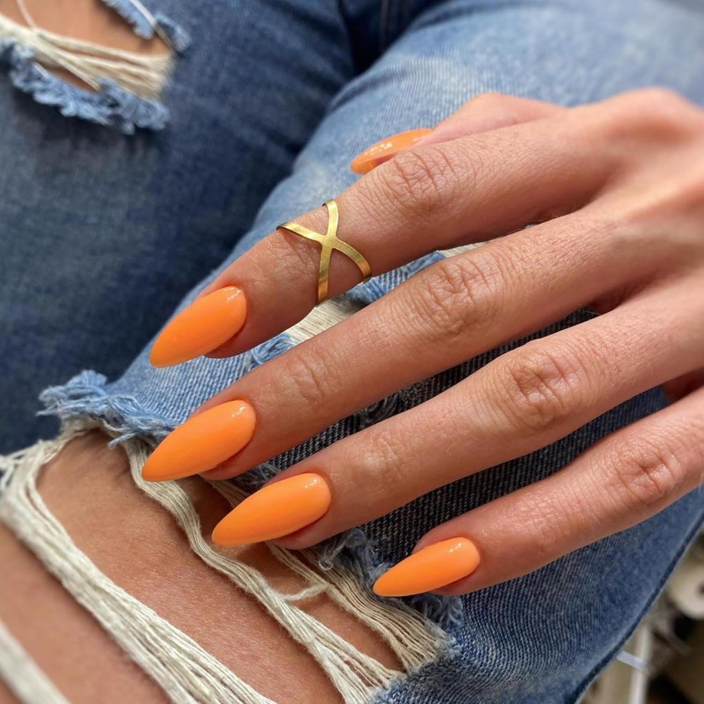 Glossy orange almond-shaped nails in a simple minimal nail design