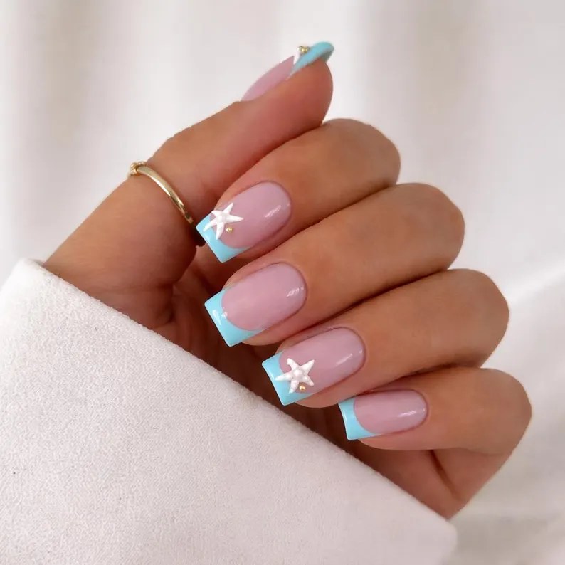Simple turquoise French tip ocean nails with tiny white starfish accents and minimalist coastal nail design