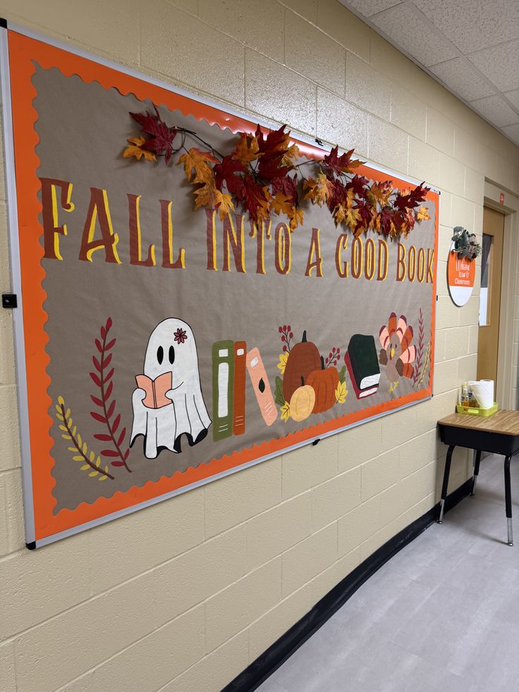 Fall reading bulletin board with books, pumpkins, autumn leaves, a reading ghost and Fall Into a Good Book lettering.