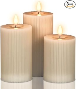 A set of three decorative LED candles with a ribbed design, varying in height, creating a warm glow.