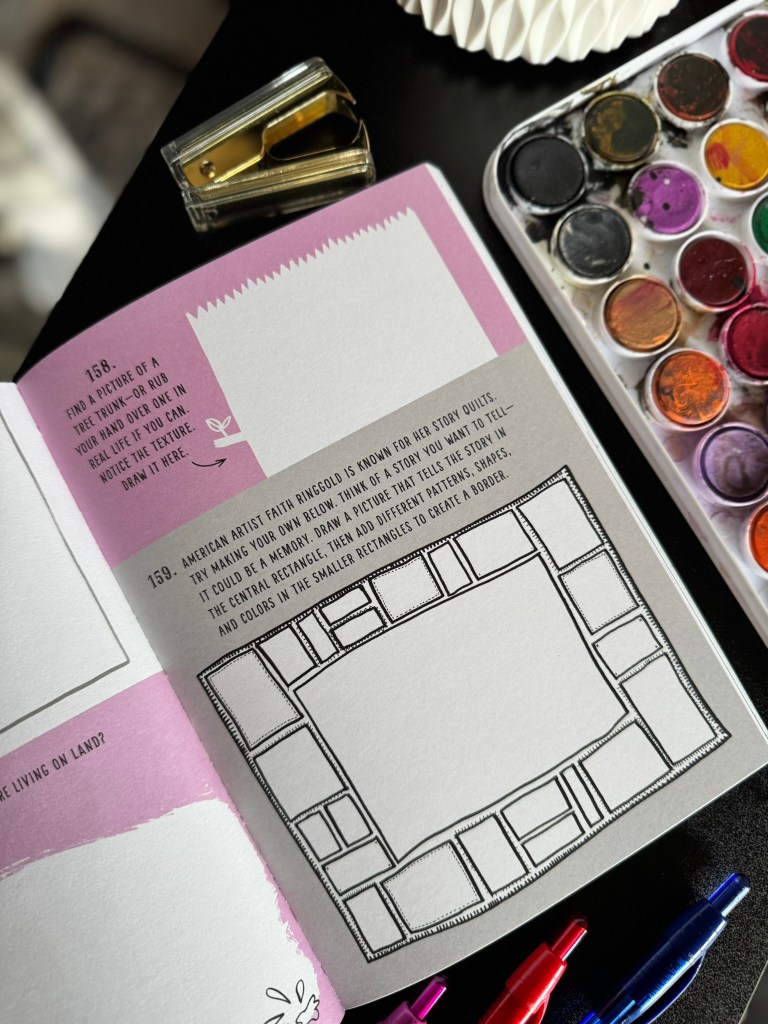 Open art book page with prompts for drawing and creativity, featuring watercolor paints and a stapler.