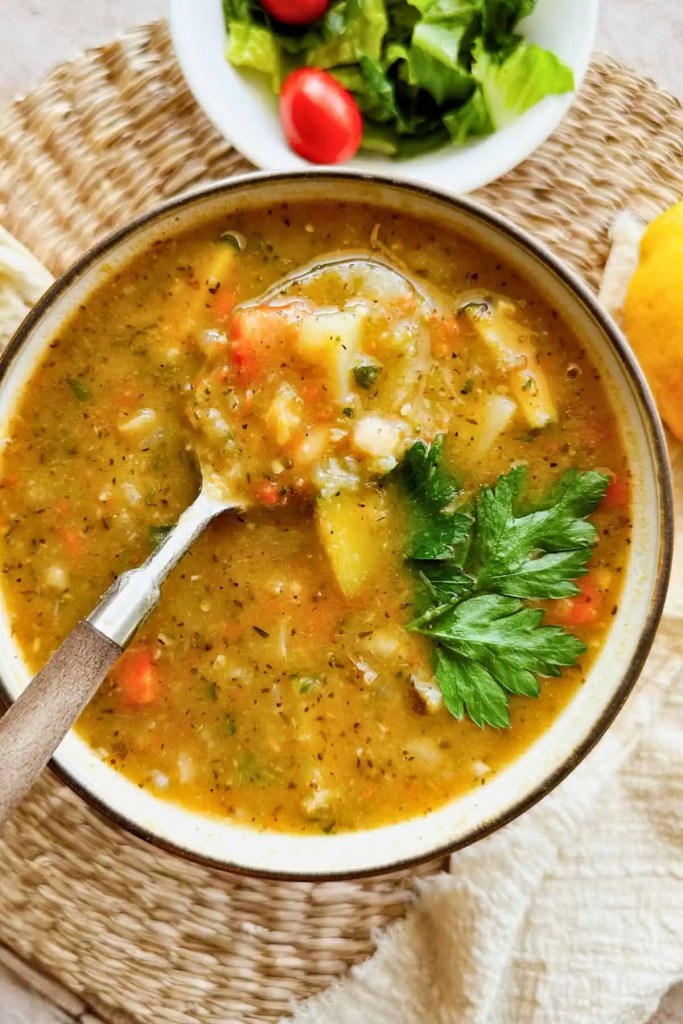 Creamy zucchini and potato soup with fresh herbs served in a rustic bowl