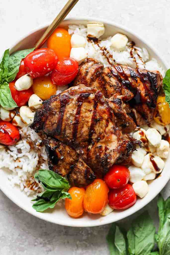 Balsamic chicken rice bowl with fresh tomatoes, mozzarella, basil, and balsamic glaze for an easy summer dinner.