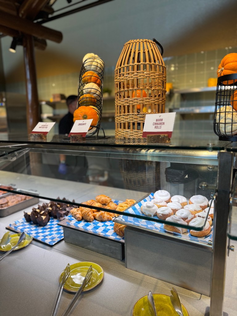 Breakfast buffet display featuring warm cinnamon rolls, assorted pastries, and fresh fruits at Great Wolf Lodge in Grapevine, TX. 