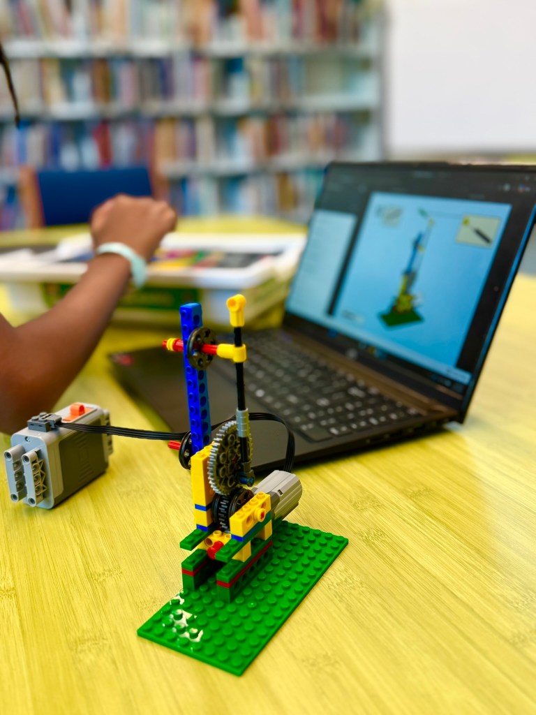 Child comparing an iBrick gear assembly to digital instructions
