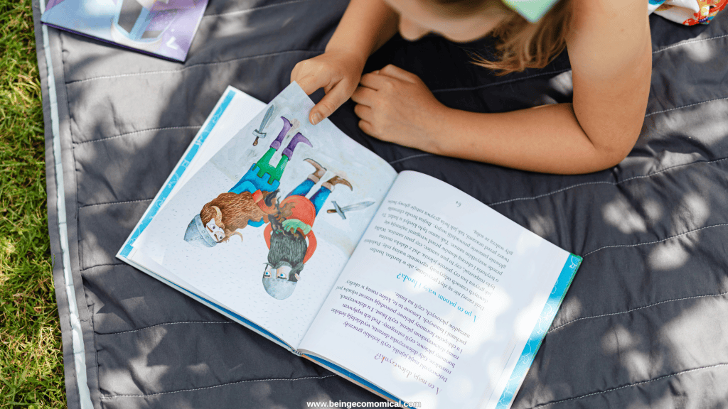 Young child reading a picture book outdoors as part of a preschool literacy activity.
