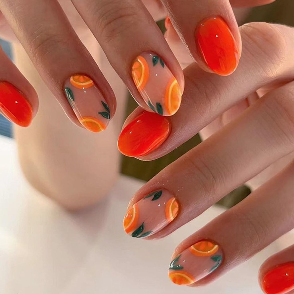 Short nails with orange slice fruit nail art and green leaf details