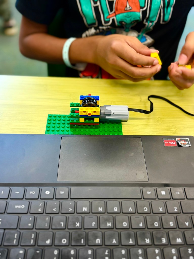 Student assembling a gear-based iBrick vehicle project