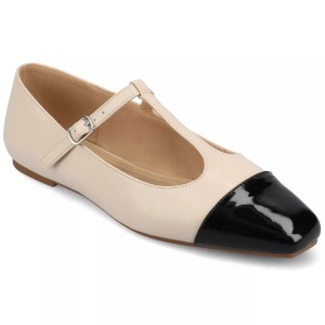 A pair of beige Mary Jane flats with a black patent cap toe, featuring a thin strap across the foot.