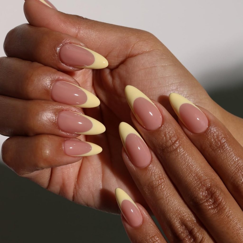 Classic butter yellow French tip nails with glossy nude base and almond shaped manicure design