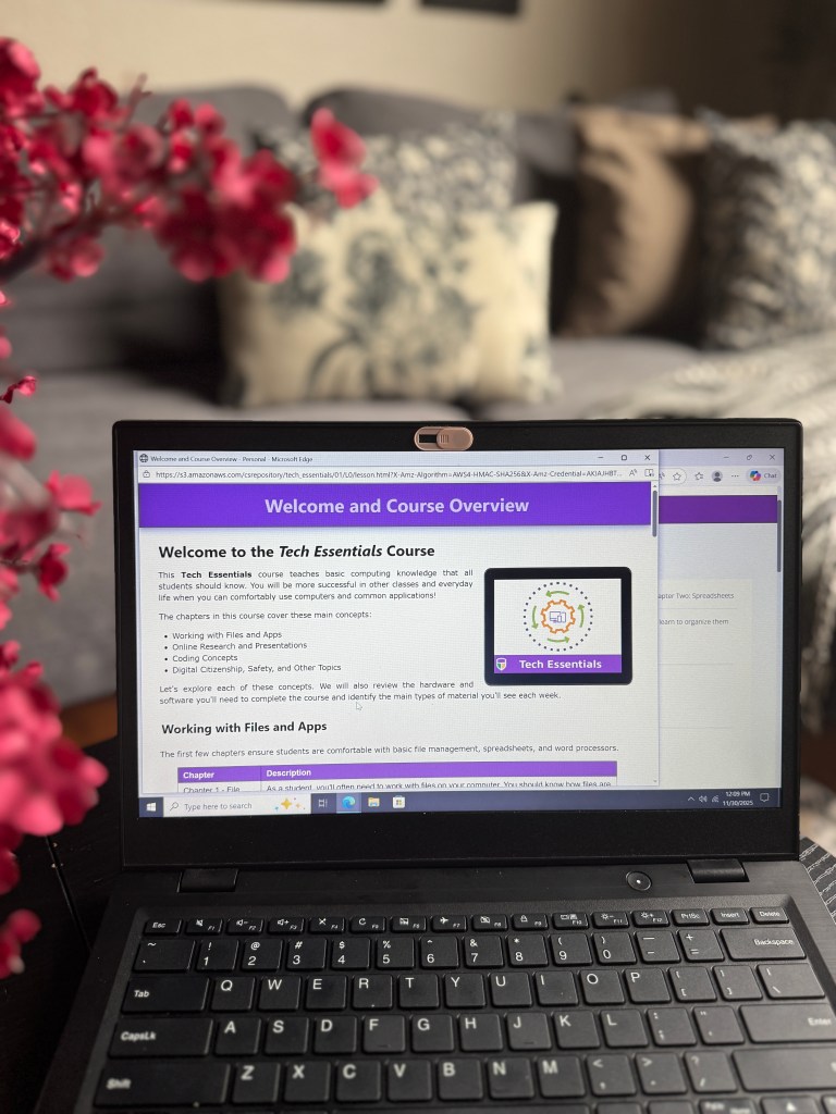 A laptop displaying the 'Welcome and Course Overview' section of the Tech Essentials course, with floral decorations in the foreground.